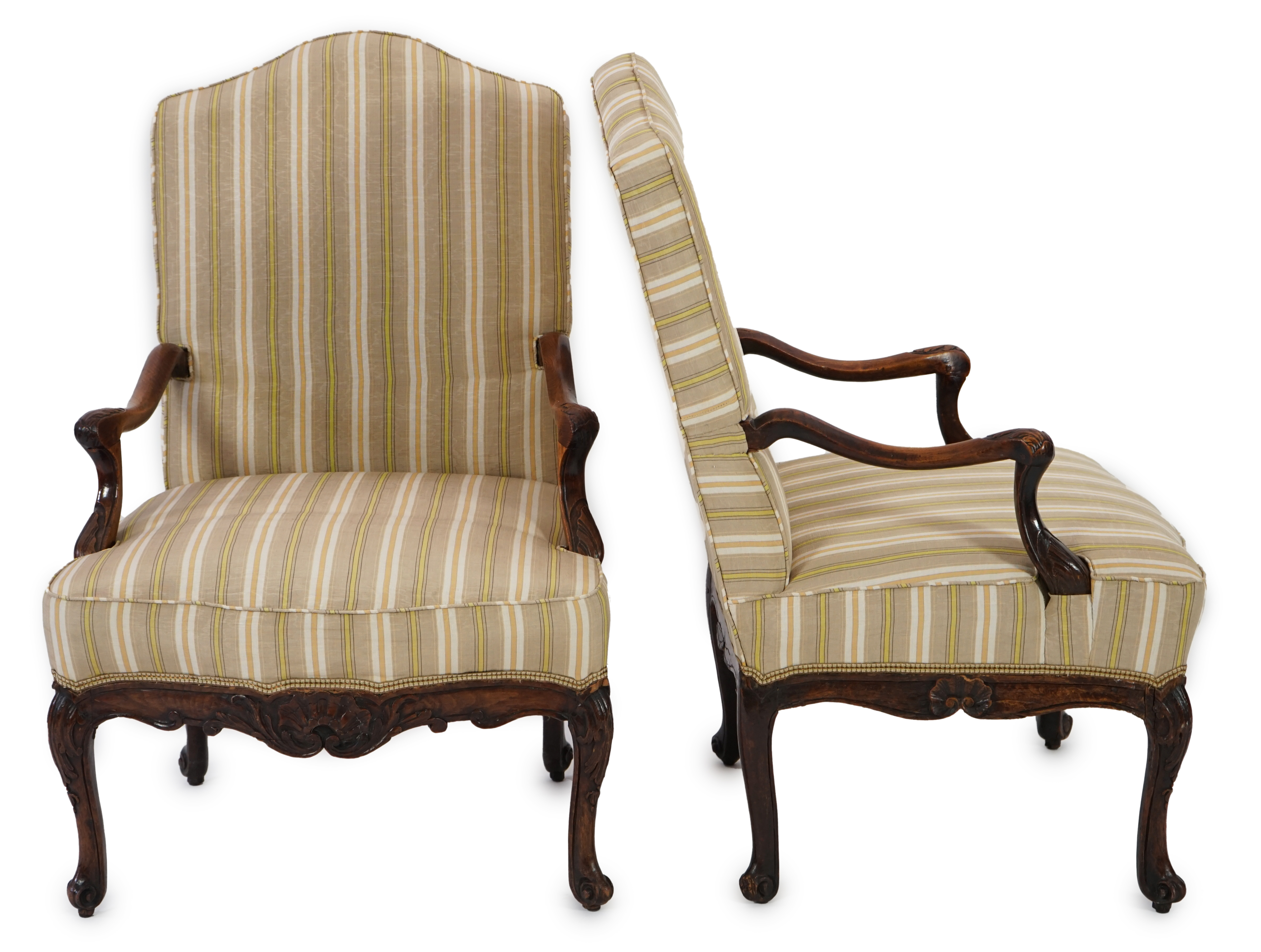 A pair of Louis XVI walnut fauteuils with upholstered backs and seats and foliate carved arms and underframes, on cabriole legs, width 67cm, depth 76cm, height 104cm. Condition - fair